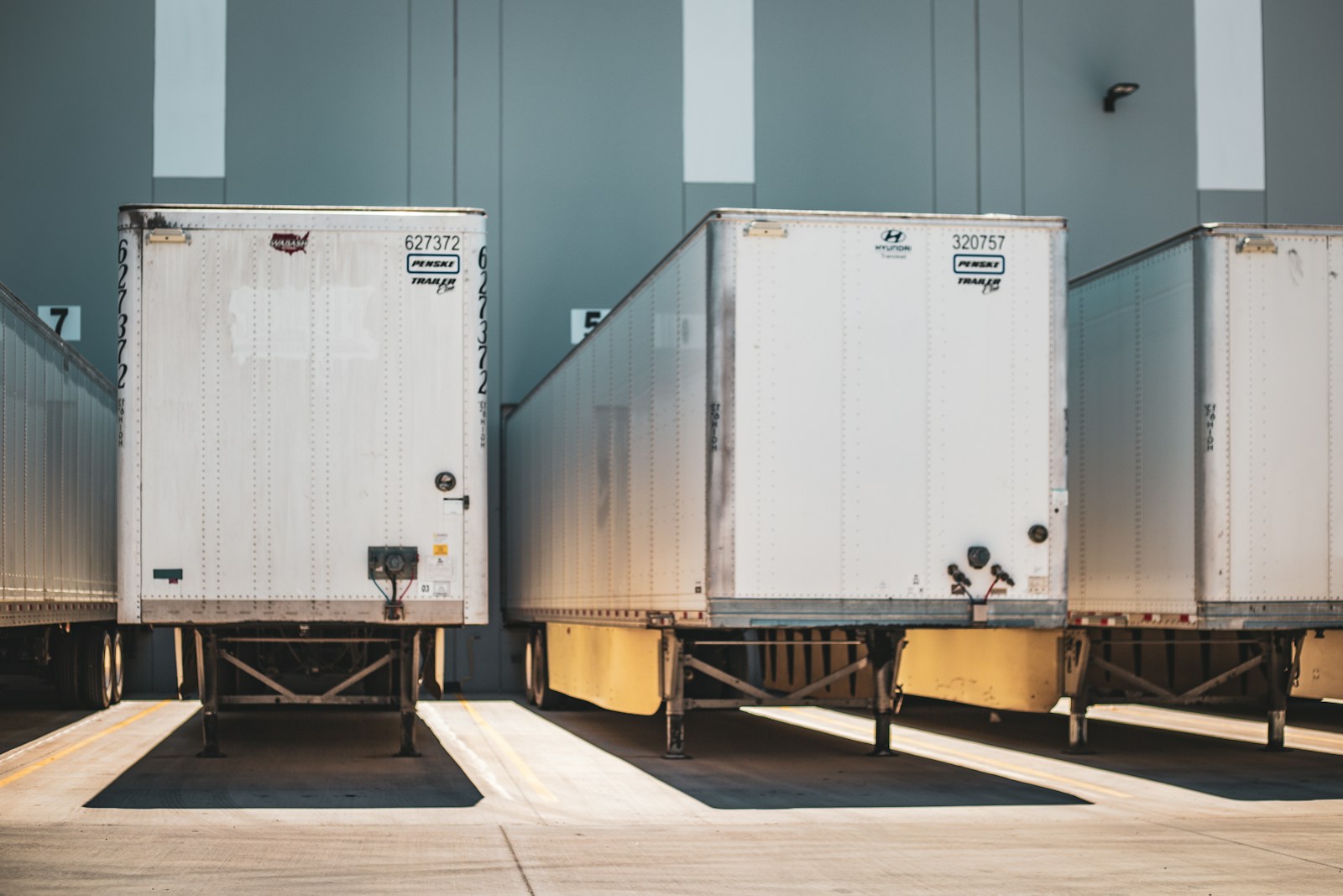 A row of identical freight trucks parked at a dedicated fleet yard