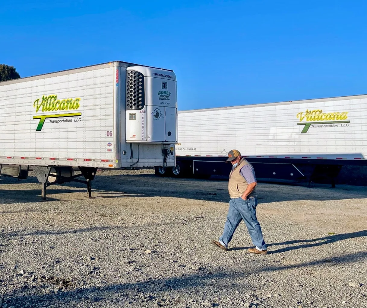 A Villicana Transportation driver walking past Villicana refrigerated trailers at the Salinas yard